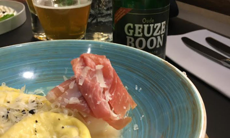 Ravioli met truffel ham op een bord met Geuze Boon erbij